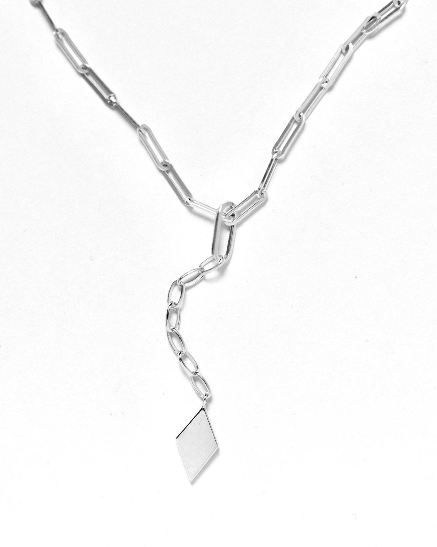 Sterling silver paperclip necklace with a silver rhomb pendant on a chain.