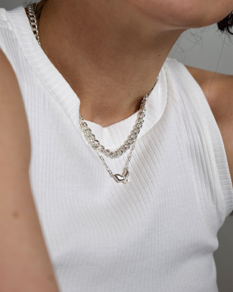 Layer of melt and curb chain necklace in sterling silver.